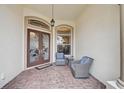 Inviting front porch with double doors and comfortable seating area at 1227 Tuscany Blvd, Venice, FL 34292