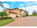 Home features a three-car garage and brick paver driveway at 206 Bella Vista Ter # 29B, North Venice, FL 34275