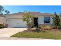Lovely single-story home with a well-kept lawn, stone accents, a black front door, and a two car garage at 2164 Midnight Pearl Dr, Sarasota, FL 34240