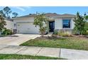 Inviting single-story home featuring a well-kept lawn, stone accents, and an attached two car garage at 2164 Midnight Pearl Dr, Sarasota, FL 34240