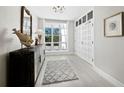 Bright entryway with a decorative mirror, unique fish sculpture, and a view to the outside at 2550 Harbourside Dr # 322, Longboat Key, FL 34228