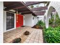 Inviting entrance with red door, tile flooring, and terracotta pots at 3746 Torrey Pines Blvd, Sarasota, FL 34238