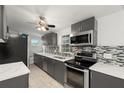 Modern kitchen with gray cabinets, quartz countertops and stainless steel appliances at 4042 Radnor Pl, Sarasota, FL 34233