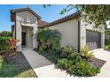 Front view of a house with walkway, landscaping and a two-car garage at 491 Casalino Dr, Nokomis, FL 34275