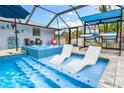 Inviting pool area with spa, lounge chairs, and screened enclosure at 531 Edlee Ln, Longboat Key, FL 34228