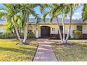 Front entrance of a single story home with palm trees at 600 Owl Way, Sarasota, FL 34236