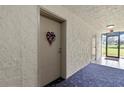 Condo hallway with carpet and door at 6114 43Rd W St # 104E, Bradenton, FL 34210