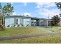Quaint light blue house with a carport and neatly trimmed lawn at 8466 Maureen Ave, North Port, FL 34287