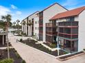 Condo building exterior showcasing a unit with a screened balcony at 1604 Stickney Point Rd # 102, Sarasota, FL 34231