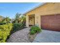 Inviting front entry with a brick walkway and lush landscaping at 2424 Post Rd, Sarasota, FL 34231