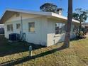 Side view of a single story home with AC unit and spacious lawn at 2710 Hibiscus St, Sarasota, FL 34239