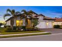 House exterior featuring a two-car garage and lush landscaping at 275 Toscavilla Blvd, Nokomis, FL 34275