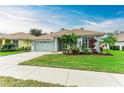 Single-story home with light gray exterior, tile roof, and landscaped lawn at 2831 Whispering Pine Ln, North Port, FL 34287