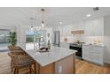 Modern kitchen with white cabinets, quartz countertops, and a large island at 3054 Markridge Rd, Sarasota, FL 34231