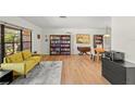 Living room with yellow couch, hardwood floors, and built-in shelves at 4410 Little John Trl, Sarasota, FL 34232