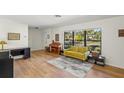 Living room with yellow couch, hardwood floors, and large window at 4410 Little John Trl, Sarasota, FL 34232