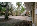 Exterior view showing a brick paver patio, lush landscaping, and exterior staircase at 5169 Oxford Dr, Sarasota, FL 34242