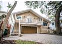 Tan two-story house with a large driveway and mature landscaping at 5169 Oxford Dr, Sarasota, FL 34242