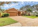 Charming single-story home with well-manicured lawn and brick driveway, lovely landscaping, and a view of the pond at 5171 51St W Ln, Bradenton, FL 34210