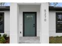 Modern front door with a glass insert and black frame, adding curb appeal at 5270 Adina Cir, North Port, FL 34291