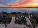 A beautiful waterfront home at sunset, featuring a brick driveway and mature landscaping at 73 Tidy Island Blvd, Bradenton, FL 34210