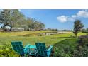 Peaceful backyard oasis with two Adirondack chairs overlooking a pond at 7872 Mainsail Ln, Sarasota, FL 34240