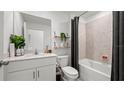 Bathroom with white vanity, bathtub, and gray shower curtain at 9100 Tequila Sunrise Dr, Sarasota, FL 34241