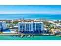 Aerial view showcasing condo building, pool, and direct water access at 9393 Midnight Pass Rd # 704, Sarasota, FL 34242