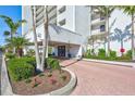 Condo building entrance with landscaping and inviting walkway at 9393 Midnight Pass Rd # 704, Sarasota, FL 34242