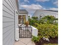 Backyard access with a wrought-iron gate and lush green landscaping at 1229 Spoonbill Landings Cir, Bradenton, FL 34209