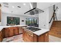 Spacious kitchen featuring wood cabinetry, a gas cooktop island, and stainless steel appliances at 13408 Swiftwater Way, Bradenton, FL 34211