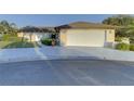 House exterior featuring a white garage door and neat landscaping at 1610 Cypress Point Ct, Venice, FL 34293
