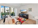 Living room with sectional sofa, large TV and access to a balcony at 1703 N Tamiami Trl # 209, Sarasota, FL 34234