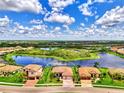 Aerial view of the home with a brick driveway, mature trees, and a three-car garage at 20686 Valprato Ct, Venice, FL 34293