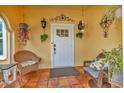 Inviting front porch with wicker chairs and hanging plants at 305 Pameto Rd, Nokomis, FL 34275