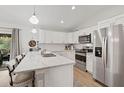 Modern kitchen featuring white cabinets, stainless steel appliances, and a large island at 3151 Johannesberg Rd, North Port, FL 34288