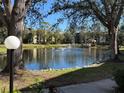Tranquil pond with fountain, landscaping, and condo building in background at 425 30Th W Ave # C212, Bradenton, FL 34205