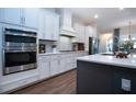 Modern kitchen featuring white cabinets, stainless steel appliances, and a gray quartz island at 4304 Fly Rod Ter, Parrish, FL 34219