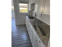 Modern kitchen with white cabinets and granite countertops at 506 Houle Ave, Sarasota, FL 34232