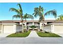 Condo building exterior showcasing walkway and tropical landscaping at 5250 Hyland Hills Ave # 1515, Sarasota, FL 34241
