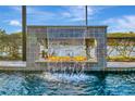 Close-up of a waterfall feature in a luxurious pool area at 5607 Tidewater Preserve Blvd, Bradenton, FL 34208