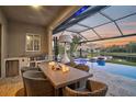 Outdoor kitchen and dining area overlooking the pool and lake at 6625 Dovekey Dr, Sarasota, FL 34241