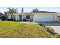 Single-story home with white brick facade, two-car garage, and manicured lawn at 7507 3Rd Nw Ave, Bradenton, FL 34209