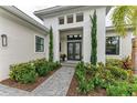 Front entry with double doors, landscaping, and walkway at 9048 Bernini Pl, Sarasota, FL 34240