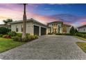Luxury home with three-car garage, paver driveway, and landscaping at 9048 Bernini Pl, Sarasota, FL 34240