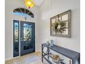 Bright entryway with decorative glass door and elegant console table at 11467 Conch Ct, Venice, FL 34292