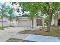 Beige house with gray door, landscaping, and driveway at 1378 Daryl Dr, Sarasota, FL 34232