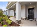 Covered porch with stone accents and a dark front door at 17020 11Th E Ter, Bradenton, FL 34212