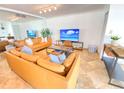 Bright living room featuring comfortable leather sofas and large TV at 1906 Gulf N Dr # 106, Bradenton Beach, FL 34217