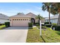 House exterior showcasing a two-car garage and manicured lawn at 204 Venice Palms Blvd, Venice, FL 34292